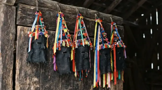 Masques noirs et chapeaux à rubans du carnaval basque, dans une grange