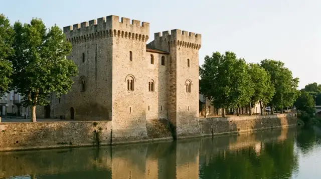 Deux maisons fortes crénelées en pierre coquillière au-dessus du quai et de la rivière