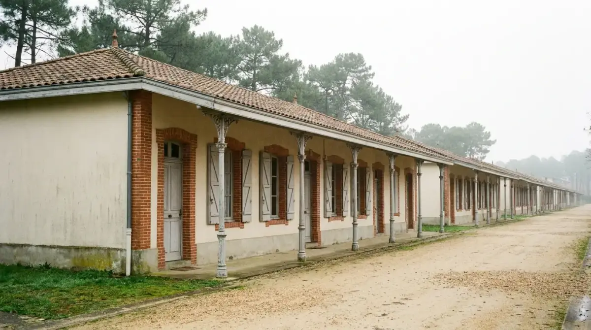Alignement de maisons basses à auvent sur colonnettes de fonte, le long de l'allée